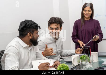 un team di uffici multirazziali sorridente che celebra insieme il successo aziendale. In un ambiente d'ufficio vivace, un gruppo eterogeneo di colleghi multirazziali si diverte. Foto Stock