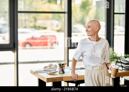 Una giovane donna calva sta con fiducia con una tazza di caffè, irradiando eleganza nell'ambiente circostante. Foto Stock