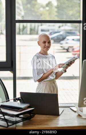 Questa giovane donna, con sicurezza calva, è vestita elegantemente mentre lavora in un ufficio contemporaneo. Foto Stock