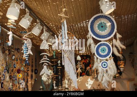 Nel negozio del mercato vengono venduti vari tipi di piume realizzate con il malocchio e magneti ricordo appesi alle pareti e al tetto Foto Stock