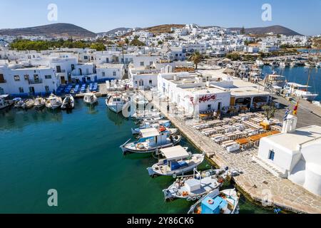 Vista aerea del pittoresco porto di Naousa nell'isola di Paros, in Grecia, con i suoi tradizionali edifici imbiancati e le vivaci barche da pesca Foto Stock