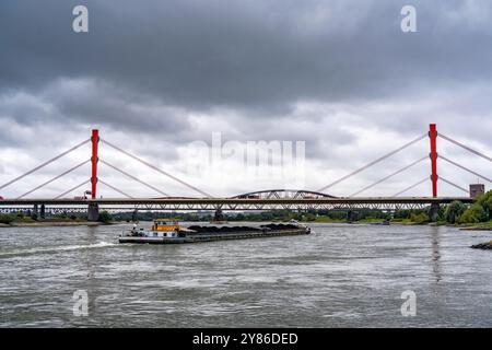 Il ponte Beeckerwerth Reno dell'autostrada A42, dietro di esso il ponte ferroviario Haus-Knipp, nave da carico sul Reno vicino a Duisburg, NRW, Germania Foto Stock