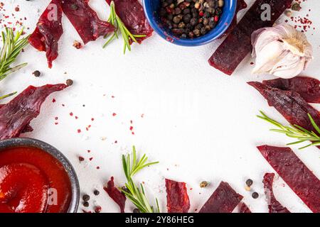 Spuntino a base di carne secca, carne di manzo a strappo. Spuntini di carne di manzo salutare, con salsa e spezie a bordo, spazio copia Foto Stock