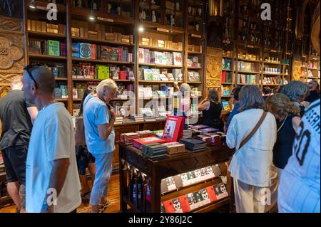 Porto, Portogallo - 12 settembre 2024 : le persone navigano e si godono vari libri in un'affascinante e vivace libreria. Foto Stock