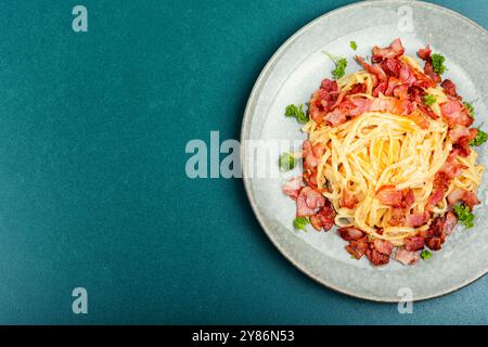 Pasta con pancetta fritta su un piatto, pasta alla carbonara. Vista dall'alto, copia spazio. Foto Stock