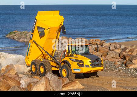 Rossal Fleetwood. Meteo nel Regno Unito 03 ottobre 2024. Partenza la mattina presto per gli appaltatori a Rossal Point. Nuovo sistema di gestione degli impianti di recupero lavori costieri. Armatura rocciosa Rossall Coastal Sea Defence veicoli con cassone ribaltabile articolato Volvo A40G. Un progetto ambizioso che prevede la fornitura di 300.000 tonnellate di aggregati per fortificare le coste. Credito; MediaWorldImages/AlamyLiveNews Foto Stock