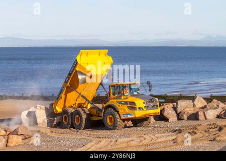 Rossal Fleetwood. Meteo nel Regno Unito 03 ottobre 2024. Partenza la mattina presto per gli appaltatori a Rossal Point. Nuovo sistema di gestione degli impianti di recupero lavori costieri. Armatura rocciosa Rossall Coastal Sea Defence veicoli con cassone ribaltabile articolato Volvo A40G. Un progetto ambizioso che prevede la fornitura di 300.000 tonnellate di aggregati per fortificare le coste. Credito; MediaWorldImages/AlamyLiveNews Foto Stock