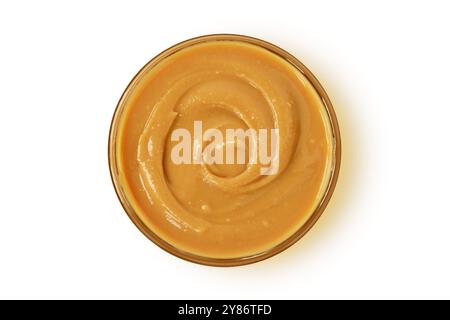 Burro di arachide in una ciotola di vetro su fondo bianco Foto Stock