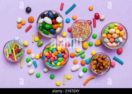 caramelle tonde di colore diverso in ciotola e vasetti. Vista dall'alto di una grande varietà di dolci e caramelle con spazio copia. Foto Stock