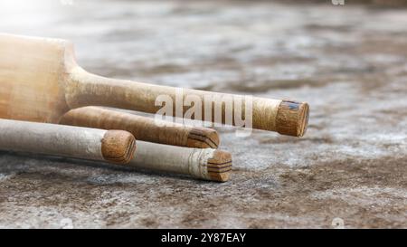 Manici di cricket in legno appoggiati su una superficie scura, simboleggiano il concetto di attività fisica attraverso il cricket e la passione dell'enthusia del cricket Foto Stock