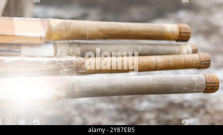 Manici di cricket in legno appoggiati su una superficie scura, simboleggiano il concetto di attività fisica attraverso il cricket e la passione dell'enthusia del cricket Foto Stock