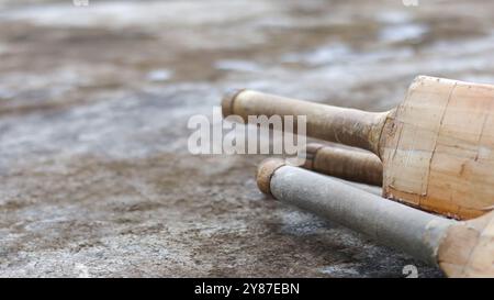 Manici di cricket in legno appoggiati su una superficie scura, simboleggiano il concetto di attività fisica attraverso il cricket e la passione dell'enthusia del cricket Foto Stock