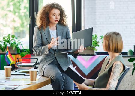 I colleghi si divertono con una discussione vivace, che mette in mostra il lavoro di squadra in un ambiente inclusivo. Foto Stock