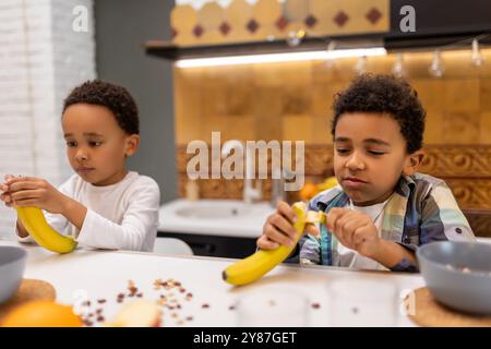 Due fratelli seduti al tavolo e a fare colazione Foto Stock