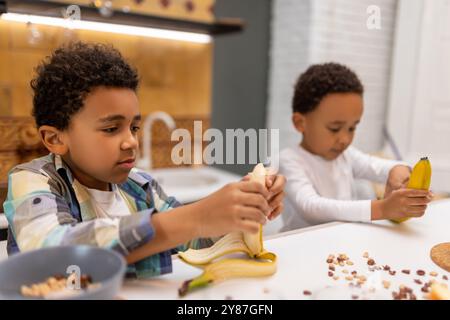 Due fratelli seduti al tavolo e a fare colazione Foto Stock
