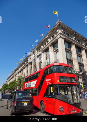 Autobus rosso a due piani con trasporto pubblico e taxi nero su Oxford Street fuori Selfridges, Westminster, Londra, Regno Unito Foto Stock