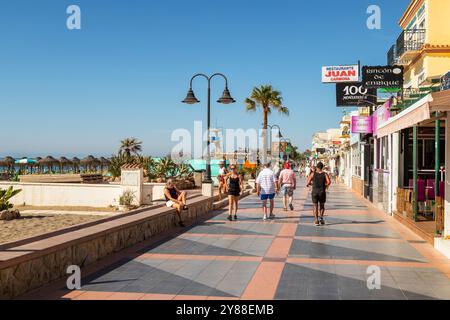 La gente cammina lungo il viale della famosa località balneare mediterranea di la Carihuela; Torremolinos. Foto Stock