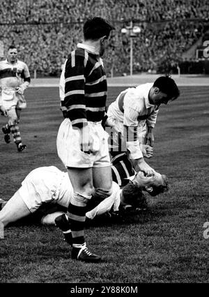 Cosa sta succedendo perché... una finale di coppa. Questo è stato uno degli incidenti del grande gioco in cui Huddersfield ha battuto St. Helens a Wembley ieri. Si', e' un bel gioco, e' il football della Rugby League, ma devi essere duro. C'erano partite per i Keeps nella finale di Rugby League a Wembley di recente. Huddersfield (maglie a strisce) ha battuto il St. Helens, 15-10. 27 aprile 1953. (Foto di Daily Mirror). Foto Stock