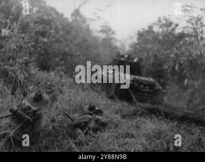 Attacco della nuova Guinea a Satelberg - truppe australiane si mossero dietro i carri Matilda per un attacco all'alba al villaggio giapponese di Satelberg. Questa foto e' stata scattata durante l'attacco vero e proprio. 6 dicembre 1943. Foto Stock