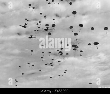 'Chutists Float Down in U.S. Air Force-Army Maneuvers - i paracadutisti del 187th Regimental Combat Team galleggiano verso il basso dopo essere saltati dai comandanti C046 della U.S. Air Force 315the Troop Carrier Wing della 315th Air Division, durante le manovre di pratica il 23 ottobre. Più di 900 soldati furono sganciati sul sud di Kyushu vicino a Kumamoto da un volo di 19 Commandos, guidati dal colonnello Adriel Williams, 3586 Gilmer Ave., Montgomery, Ala., 315th Wing Commander. La 315th Air Division e la 137th RCT hanno funzionato come una squadra aerea durante la guerra di Corea. 28 ottobre 1953. (Foto di U.S. ai Foto Stock