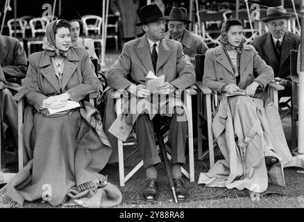 Royal Windsor Horse Show -- la Principessa Elisabetta e la Principessa Margaret Rose erano ben avvolte contro la pioggia al Royal Windsor Horse Show di oggi. Seduto tra di loro c'è il Duca di Beaufort, presidente dello show. Il Royal Windsor Horse Show di due giorni ha aperto a Windsor tutti i giorni, venerdì. 31 maggio 1946. Foto Stock