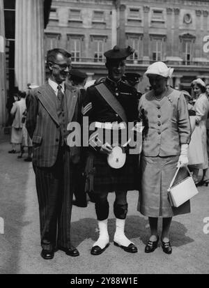 Kilted Aussie -- il sergente Robert Beattie Australian che serve nel Black Watch, crack Scots regment, con i suoi genitori dopo che era stato decorato con la Military Medal dalla Regina in un'investitura a Buckingham Palace, Londra, oggi (martedì). Il sergente Beattie è nativo di Victoria. 27 luglio 1955. (Foto di Reuterphoto). Foto Stock