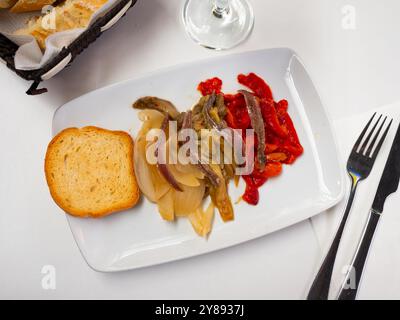 Vista superiore della tradizionale catalana escalivada da melanzane alla griglia, la cipolla e il peperone servita con i filetti di acciuga Foto Stock