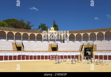 Arena storica con architettura classica e cielo blu, pavimento in sabbia e sedie nel centro, Plaza de Toros, Antequera, Malaga, Andalusia, Spagna, E. Foto Stock
