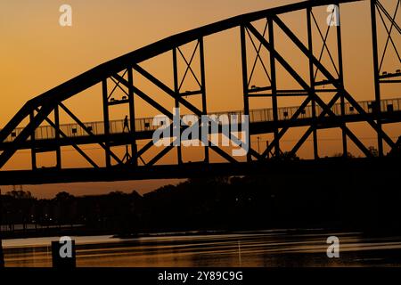 Il sole sorge sul ponte William J. Clinton che conduce al Presidential Museum and Library di Little Rock, Arkansas, 2 ottobre 2024. Foto Stock