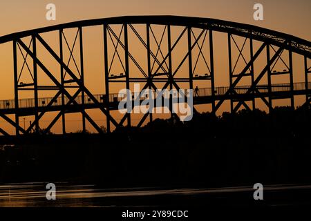 Il sole sorge sul ponte William J. Clinton che conduce al Presidential Museum and Library di Little Rock, Arkansas, 2 ottobre 2024. Foto Stock