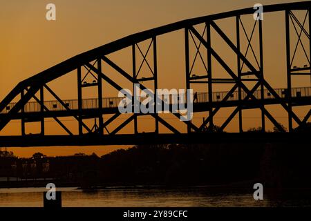 Il sole sorge sul ponte William J. Clinton che conduce al Presidential Museum and Library di Little Rock, Arkansas, 2 ottobre 2024. Foto Stock