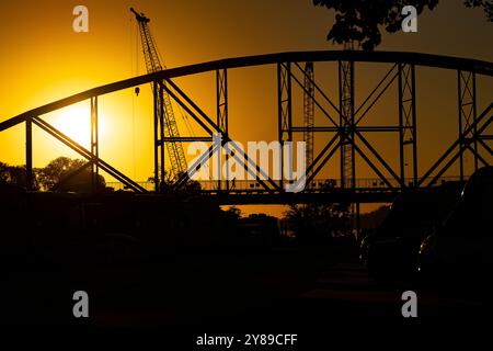 Il sole sorge sul ponte William J. Clinton che conduce al Presidential Museum and Library di Little Rock, Arkansas, 2 ottobre 2024. Foto Stock