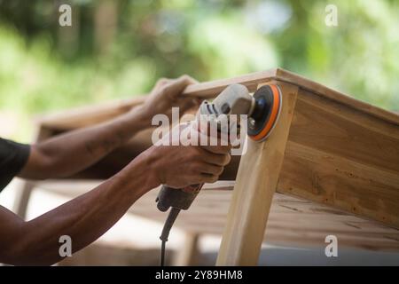 i falegnami lavorano levigando il legno con una macchina Foto Stock