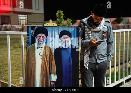 Distretto di Bartella, Iraq. 30 settembre 2024. Un uomo si trova accanto a uno striscione, tra cui ritratti del leader supremo iraniano Ayatollah Ali Khamenei (L), Hassan Nasrallah (R), durante un servizio commemorativo per Hassan Nasrallah, il defunto leader del gruppo sciita libanese Hezbollah che è stato ucciso in un attacco aereo israeliano a Beirut giorni fa, nel distretto di Bartella a est di Mosul, nel nord dell'Iraq. Credito: SOPA Images Limited/Alamy Live News Foto Stock