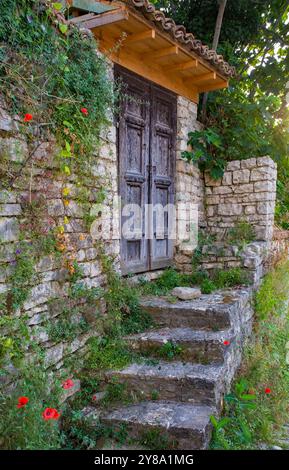 Una doppia porta in legno con gradini che vi conducono in una storica casa in pietra nel quartiere Gorica di Berat, Albania. Berat è un sito patrimonio dell'umanità dell'UNESCO Foto Stock