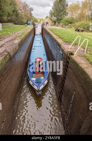 Barca stretta che attraversa una chiusa deepida sul canale Trent & Mersey tra Kings Lock e il pub "Big Lock". Foto Stock