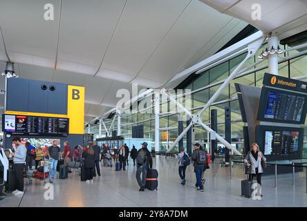 Vista interna del nuovo edificio del Terminal 2 presso l'aeroporto Heathrow di Londra, Regno Unito. I passeggeri riempiono la trafficata sala partenze. Foto Stock