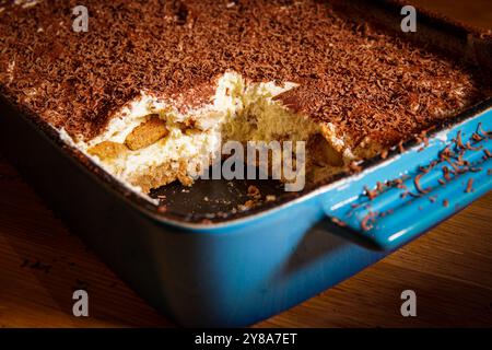 Tiramisù italiano in una ciotola rettangolare smaltata in ghisa blu su un tavolo da cucina Foto Stock