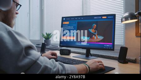 L'uomo adulto con le cuffie entra in chat con intelligenza artificiale sul personal computer. L'applicazione generatore video IA genera video dettagliati di ballerina danzante. Creazione avanzata di video generati dall'intelligenza artificiale Foto Stock