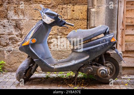 Scooter d'epoca parcheggiato fuori dal muro del vecchio edificio. Italia Foto Stock