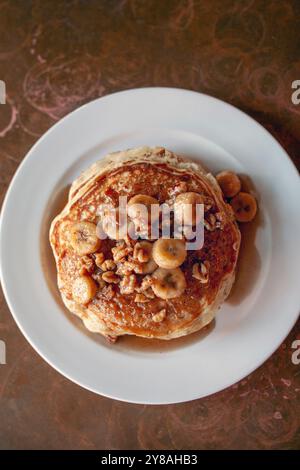 Vista dall'alto di una pila di pancake con banane in verticale Foto Stock