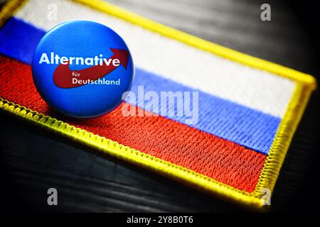 Distintivo AFD sulla bandiera russa, foto simbolica per una possibile vicinanza dell'AfD alla Russia, Parteianstecker der AfD auf einer Fahne von Russland, Foto Stock