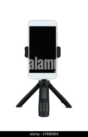 Un telefono cellulare montato su un treppiede, su sfondo bianco, che offre versatilità per la fotografia. Foto Stock