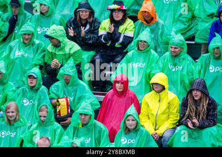 TEMPESTA ESTIVA, BEACH VOLLEY, MARIEHAMN, 2011: La folla si copre con poncho antipioggia usa e getta mentre un'enorme tempesta estiva attraversa lo stadio con un diluvio di pioggia durante le semifinali dell'agosto 2011 al PAF Open di Mariehamn, Åland, Finlandia. Fotografia: Rob Watkins. INFO: Tra il 2009-2013 il PAF Open Beach Volley è stato un torneo annuale che si è tenuto a Mariehamn, Åland, Finlandia. Ha attirato le migliori squadre e giocatori internazionali come parte della classifica ufficiale del FIVB World Tour, mostrando pallavolo da spiaggia di alto livello. Foto Stock