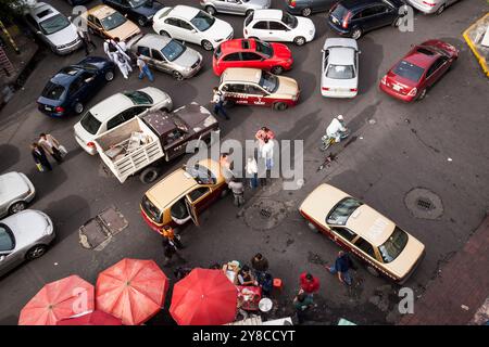 Vista dall'alto del traffico caotico dell'ora di punta al mattino presto all'incrocio di strade. I tassisti chiacchierano, bloccando l'angolo di Roma, città del Messico Foto Stock