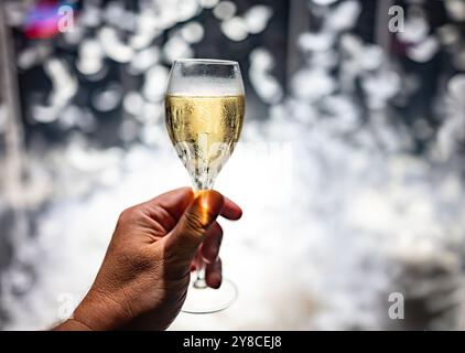 Festeggiamenti, molte piume bianche volano in aria sullo sfondo, night club con pigiama party e bicchiere di champagne spumante, ballo con vino, wedd Foto Stock