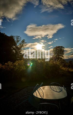 Il tramonto di settembre getta ombre sulle sedie e sul tavolo esterni vuoti in Scozia Foto Stock