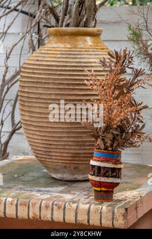 Due vasi decorativi in terracotta contenenti fiori secchi, un vaso colorato e un grande vaso in terracotta fioriera con fiori secchi su Zante, Foto Stock