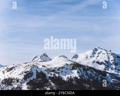 Una splendida vista sulla cima innevata del Serre Chevalier di Brianza, su un cielo azzurro e limpido. L'aspro paesaggio montano ne mette in mostra la bellezza Foto Stock