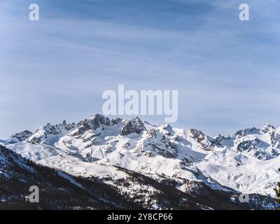 Una splendida vista sulla cima innevata del Serre Chevalier di Brianza, su un cielo azzurro e limpido. L'aspro paesaggio montano ne mette in mostra la bellezza Foto Stock